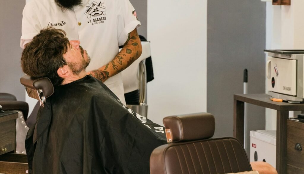 man in white t-shirt sitting on barber chair